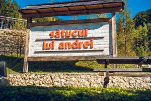 een bord voor een safari die niet leuk is naast een bankje bij Sătucul lui Andrei in Sătic