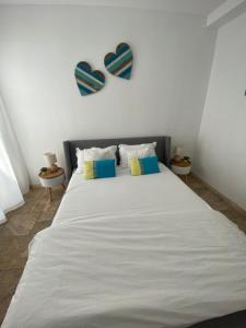 1 dormitorio con 1 cama blanca grande y 2 corazones en la pared en 59 Kaliakria Seaview Luxury Apartment, en Topola