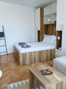 a bedroom with a large bed and a table at Apartman Rajska Banja in Vrnjačka Banja