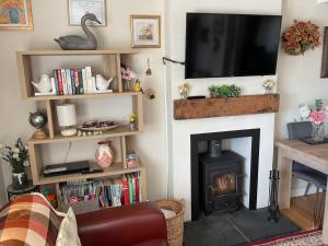 a living room with a fireplace with a flat screen tv at Captivating 2-Bed Cottage in Grewelthorpe in Grewelthorpe