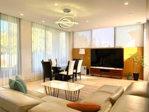 a living room with a couch and a dining room at Luxury Residence, Short drive to Olympic Park in Sydney