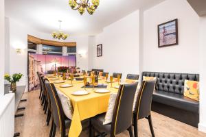 uma sala de jantar com uma mesa longa e cadeiras em Christian Retreat Holiday Let em Blackpool