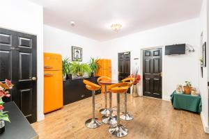 uma cozinha com armários e bancos cor-de-laranja e preto em Christian Retreat Holiday Let em Blackpool