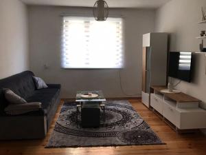 a living room with a couch and a tv at Apartman Mario in Bihać
