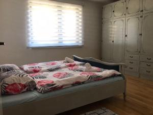 a bed with a blanket on it in a bedroom at Apartman Mario in Bihać