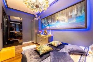 a bedroom with a large bed and a chandelier at Apartament Wonderland by Managerent in Słupsk