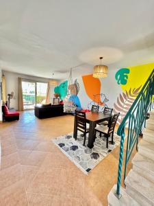 5-BRS Villa Steps from Beach Cozy vibes في العين السخنة: غرفة معيشة مع طاولة و لوحة على الحائط