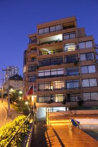 un edificio alto con luces encendidas en una ciudad en Apartamento en Reñaca con Vista al Mar, en Viña del Mar