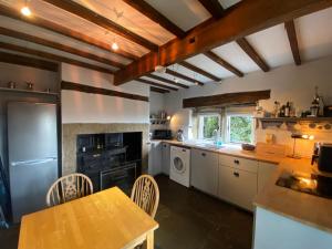 a kitchen with a table and chairs in a room at Sculpture Park Cottage in Penistone