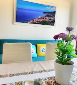 un tavolo con un vaso con fiori viola di Luxury Apartment Vanacore a Castelnuovo Cilento