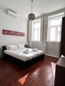 um quarto com uma cama e duas janelas em Covelo Apartment no Porto