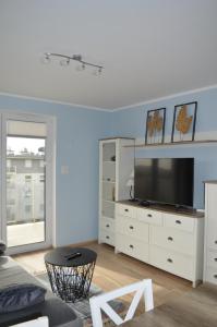 - un salon avec une télévision sur une commode blanche dans l'établissement Apartament Rakownica, à Jelenia Góra