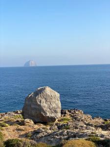 una gran roca en la orilla de un cuerpo de agua en SPITIA VASILI en Kapsálion