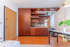 a kitchen with wooden cabinets and a table and chairs at Tra Storia, Benessere e Natura in Montecatini Terme