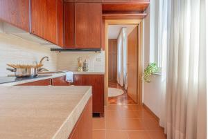 a kitchen with wooden cabinets and a tile floor at Perfect Spa Location - Between Pisa, Lucca and Florence! - Netflix & Youtube Premium included in Montecatini Terme