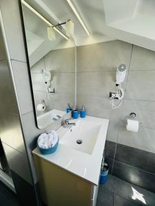 uma casa de banho com um lavatório e um espelho em Sky Loft em Alba