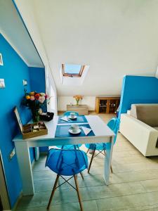 a living room with a table and a blue wall at Sky Loft in Alba