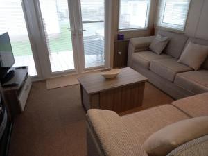 科克茅斯的住宿－Green Dream，客厅配有沙发和桌子