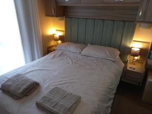 科克茅斯的住宿－Green Dream，一间卧室配有一张大床和两条毛巾