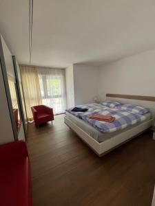 een slaapkamer met een bed en een stoel erin bij casa ciliegio in Vogorno