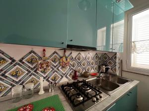 a kitchen with a sink and a stove top oven at Terrazza Faraglioni in Acitrezza