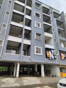 a large gray apartment building with people in the balconies at 2BHK AC Service Apartment 103 in Pune +111 photos