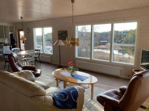 ein Wohnzimmer mit einem Sofa und einem Tisch in der Unterkunft Kalles, skärgårdsidyll med utsikt över Hamnsundet in Saltvik