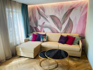 ein Wohnzimmer mit einem Sofa und einem Blumenbild in der Unterkunft Boutique - Hotel Zum Schloss in Amtzell