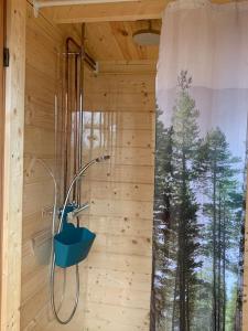 a shower in a wooden room with a window at Kalles, skärgårdsidyll med utsikt över Hamnsundet in Saltvik