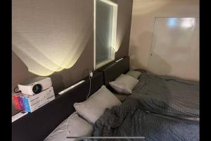a small bedroom with a bed and a window at Monster lodge 札幌 in Sapporo