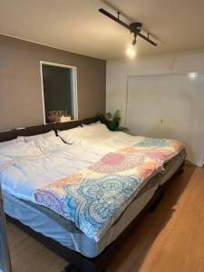 un grand lit dans une chambre avec un ventilateur de plafond dans l'établissement Monster lodge 札幌, à Sapporo