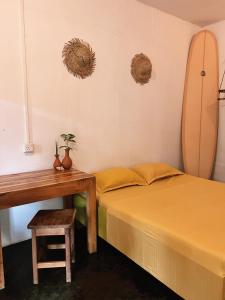 1 dormitorio con 2 camas y una tabla de surf en la pared en Wave Hunters, en Arugam Bay