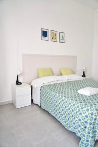 una camera bianca con letto e comodino di Amoenus Bed & Breakfast a Soverato Marina