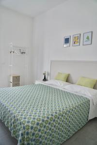 a bedroom with a bed with a green and white comforter at Amoenus Bed & Breakfast in Soverato Marina