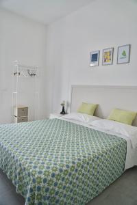 a bedroom with a bed with a green and white comforter at Amoenus Bed & Breakfast in family in Soverato Marina