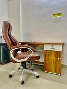 a brown office chair sitting in front of a desk at 2BHK AC Service Apartment 103 in Pune