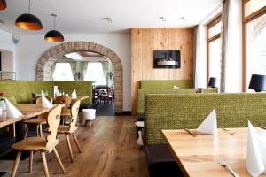 um restaurante com mesas de madeira e cabinas verdes em Südtiroler Stuben em Essen