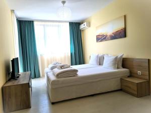 een slaapkamer met een groot bed en een raam bij Apartments Stamopolu Lux with pool view in Primorsko