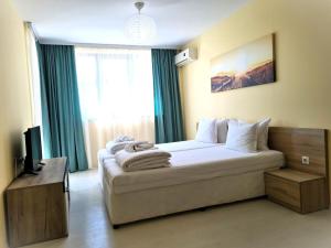 Un dormitorio con una cama grande con ventana. en Apartments Stamopolu Lux with pool view, en Primorsko