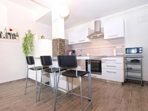 una cocina con sillas negras y armarios blancos en Ferienwohnung für 6 Personen ca 75 qm in Fažana, Istrien Istrische Riviera - b54751, en Fažana