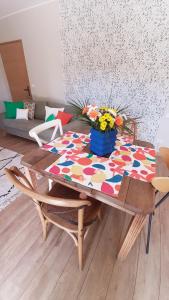 una mesa con un colorido mantel con flores. en P'tit cocon au cœur du Lot, en Dégagnac