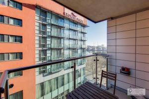 a balcony of a building with a bench in front at Stylish Three Bedroom Apartment by London ExCeL in London