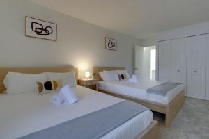 duas camas num quarto de hotel com paredes brancas em Condo Near to Metro Station at Crystal city em Arlington