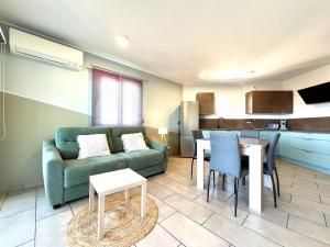 a living room with a green couch and a table at Appartement ALERIA 2/4 personnes in Aléria