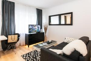 ein Wohnzimmer mit einem Sofa und einem TV in der Unterkunft Little Oasis Near Frankfurt in Neulsenburg