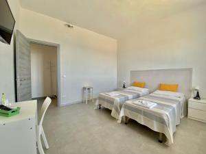 1 dormitorio con 2 camas y mesa. en Amoenus Bed & Breakfast, en Soverato Marina