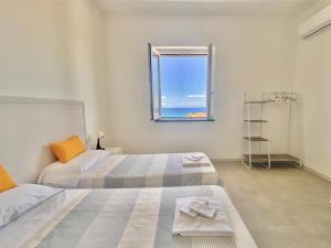 a bedroom with two beds and a window at Amoenus Bed & Breakfast in family in Soverato Marina