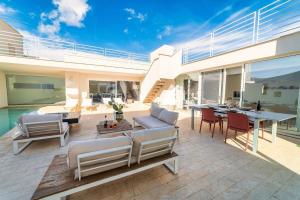 un patio con sofás, mesa y sillas en Ferienhaus mit Privatpool für 4 Personen ca 380 qm in Torretta, Sizilien Nordküste von Sizilien, en Torretta