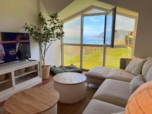 sala de estar con sofá y ventana grande en Apartamento Suite mirando al mar, en Porto de Espasante