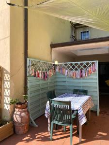 eine Terrasse mit einem Tisch, Stühlen und einer Wäscheleine in der Unterkunft Caligo in La Spezia